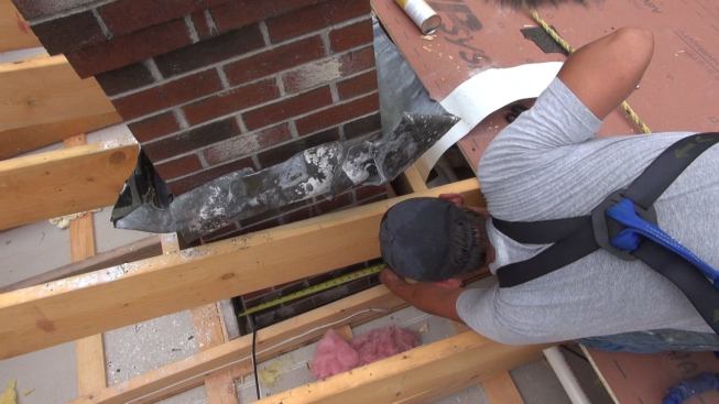 Phillips measures the length of the chimney chase opening.