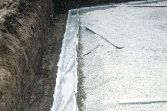 Installing polyethylene under a concrete footing prevents ground moisture from wicking up the basement walls.