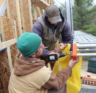 Steve and Caleb attach a safety net clip to the upper staging plank.