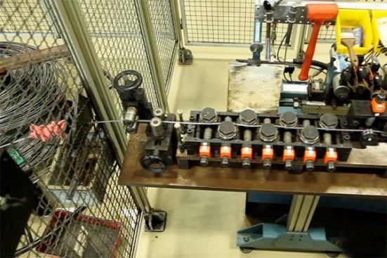 The steel enters from the left and passes through a series of rollers that make it perfectly straight.