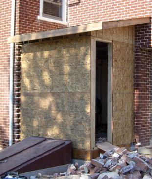 The crew left a section of sheathing off the addition so they could more easily remove the brick from inside.
