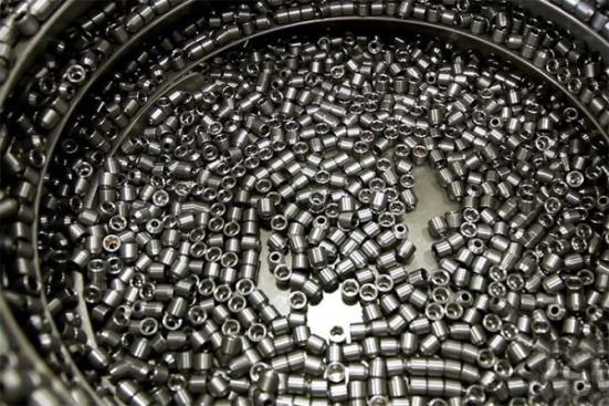 These pieces are about to become the business ends of nut drivers. When the machine on the pieces spin to the perimeter, are put in the correct orientation, and then channeled to the welding machine.