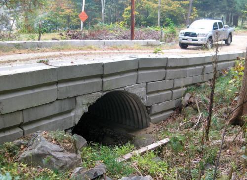 The approach ramps of open-bottom culverts are usually retained with stacked precast block--difficult to arrange in a neat arch and too industrial looking for the author on this site.