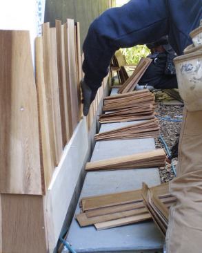 To speed production, shingles are sorted into piles spaced 3 or 4 feet apart along the wall with the tips oriented in the same direction.
