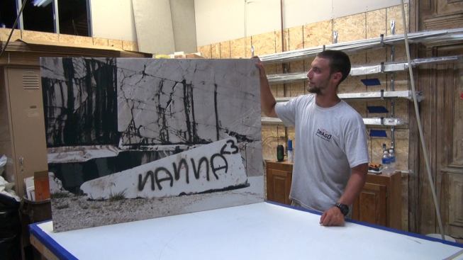 A crew member shows the completed panel before wrapping it in plastic for storage, then delivery to the job site.