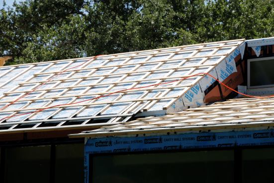 Architects designed a very cool "over-roof" with 2x's to create overhangs on this house. Roof has continuous ventilation under the metal from eave to ridge.