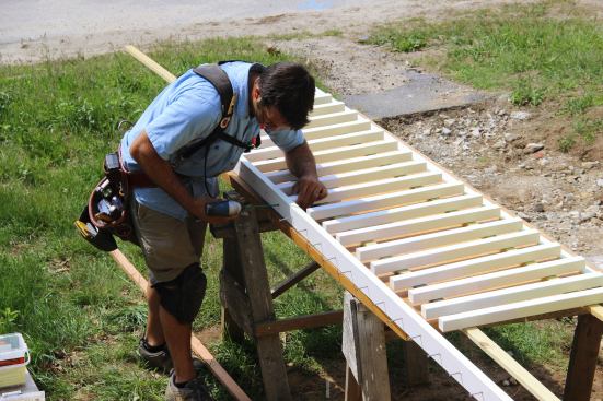 Pollard works his way along the bottom rail, setting a screw through the pre-drilled hole into the end of each baluster.