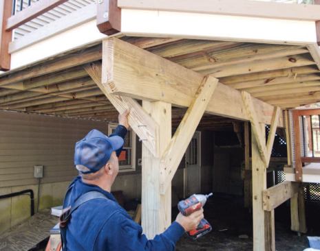 The author's crew installs Y-bracing to resist side-to-side movement parallel to the house.