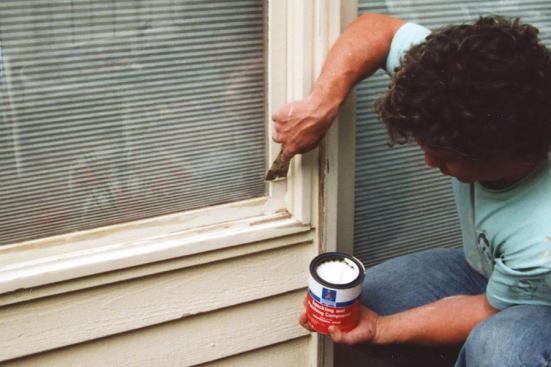 After scraping, the author fills small holes and minor gouges with a quick-drying spackling compound.