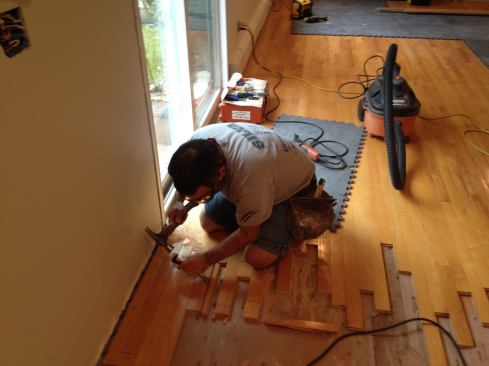 Remove the tongue section of the waste board first with a pry bar. The groove side should then pop out easily. When the wood is removed, be sure to remove the nails and clean out any splinters or debris that might interfere with installing the new board.