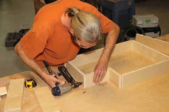 After cutting plywood pieces to the required length, Jeff tacks the toe-kick base together using 1 1/4-inch staples with a 1/4-inch crown.