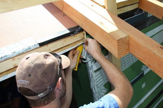 Applying Wigluv tape to the head jamb.