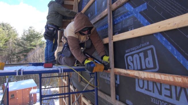 Kruse’s crew wraps and straps the north wall of the addition. The airtight Mento Plus fabric over the I-joist buildout forms the air pressure control layer as well as the weather-resistive drainage plane for this wall system. Criss-cross wall strapping will serve as nailing for wood siding.