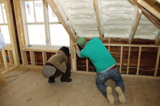 Rachel Conly and Shane Fenton locate and seal small air leaks during blower door testing.