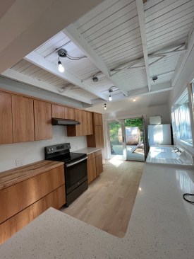 Once new countertops and flooring had been chosen, the kitchen neared completion. The owner chose to leave the ceiling beneath the upstairs floor exposed, but she had not yet made a lighting selection at the end of the job. 