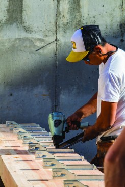 Working off ladders can be very time consuming, so whenever the crew could, they attached joist hangers to the floor structure before it was lifted into place.