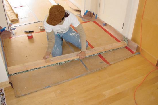The top and bottom plates of temporary dust partitions are padded with strips of sill seal or carpet padding.