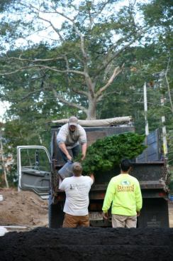 The landscapers unload potted trees that had been donated. By weeks end, the backyard had been sodded, and the brick-paver walk led visitors up to the front door.