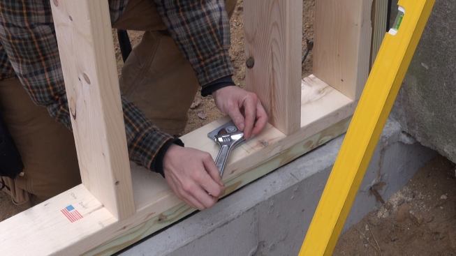 Laffin tightens down a foundation anchor bolt.
