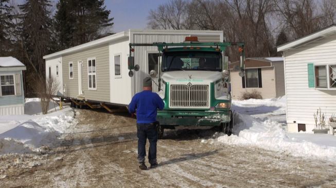 Steve Davis guids the truck and trailer carrying the modular unit into the moblie home park.