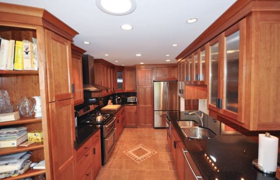 The finished kitchen features custom cherry cabinetry and a tough porcelain tile floor dressed up with stone tile insets.