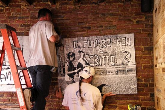 The crew screws a pair of “REVRB” panels into the brick wall of the restaurant. Using art chosen by the restaurant owner and screen-printed onto appropriate fabric, then attached to the sound-absorbing fiber-lined panels, enhances both the esthetics and the auditory comfort of the dining area. The same method can be employed in many kinds of public space, from doctor’s offices to conference rooms, classrooms, home listening rooms, or auditoriums.