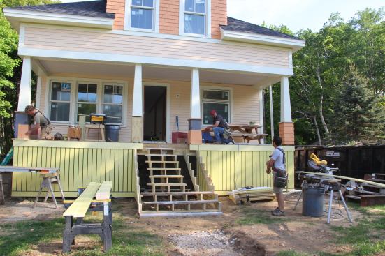 Mark Pollard, Shane Fenton, and Dale Cunningham work on porch stairs and columns in May.