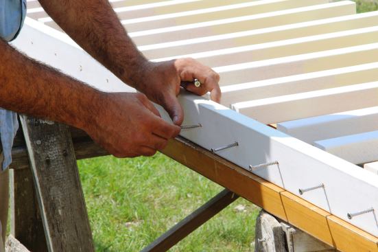 Pollard sets screws into his pre-drilled holes in the bottom rail.