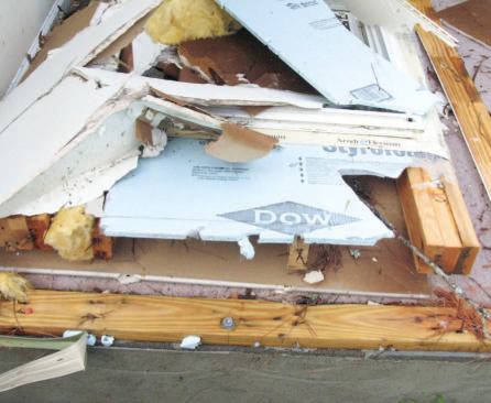 The home's bottom plate — shown with bits of the foam sheathing still attached — was intact; structural wall sheathing would have greatly strengthened this connection between the wall studs and the bottom plate.