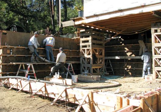 Concrete is pumped into one of the new basement walls.