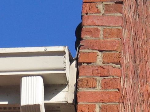 On older buildings that have been re-roofed multiple times, the existing through-wall flashing often gets cut flush with the front face of the brick, as was the case on this parapet end wall. At some point, a roofer came in and cut off the exposed leg of the counterflashing in order to get a new roof down, and then he installed saw-cut flashing. What he should have done is left some of the exposed counterflashing in place and slid new flashing skirts under it, pop-riveting or screwing the two together.