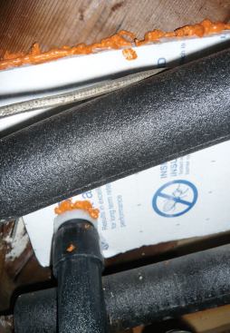 A small filler piece at the drainpipe is foamed in place to complete the seal.