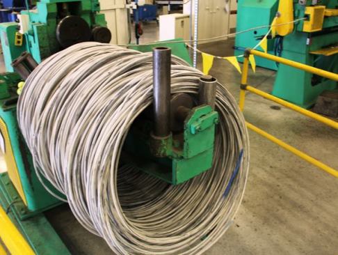 The material for sockets arrives at the plant as coiled steel. Here it is being fed into a machine that will straighten it and then cut it into short slugs or billets.