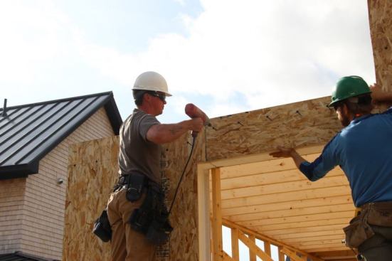 Carpenters attach the panel section to the stud wall frame using long hardened screws supplied by R-Control.
