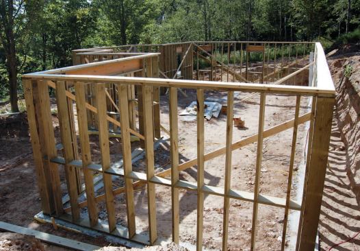 The top member of the doubled top plate can be assembled from conventional untreated framing lumber, lapped at the corner as in standard framing.