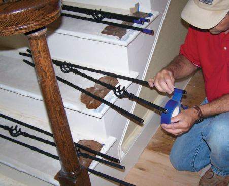 Both epoxy and construction adhesive tend to get everywhere, so I wrap the base and top of each baluster with masking tape before installation to make clean-up easier.