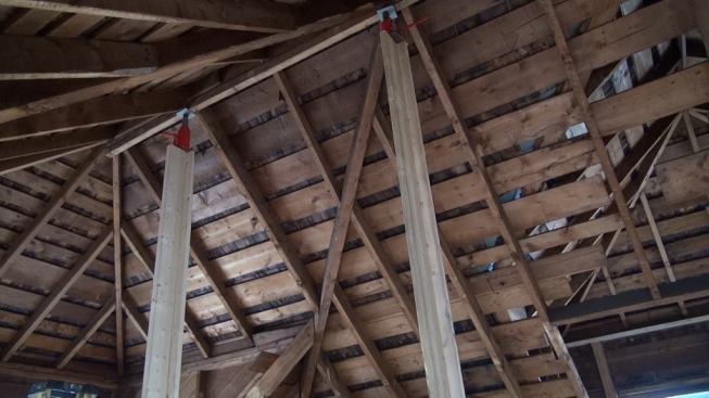 With the first and second floor straight, the crew returned to the effort of pulling in the upstairs kneewalls and jacking up the ridge. When comealongs across the span of the house couldn’t do the job, they installed four posts with bottle jacks under the ridge to lift the ridge directly. But the house still resisted — until the crew reframed the porch at the front of the house and jacked the new beam into level. “Then the comealongs immediately sagged and the ridge started to go up,” says Mark Pollard.