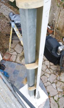 We fastened the first half of the column to the masonry base and the boxed-out soffit with L-clips, then — using construction adhesive and countersunk screws — installed pairs of 2-by splice blocks.