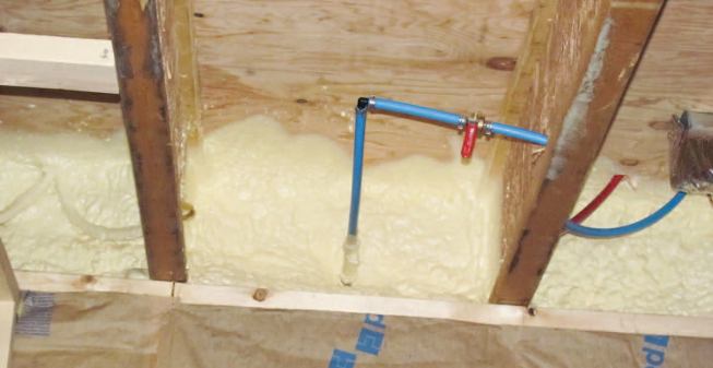 Note the air-sealing tape over the seams. Spray foam on the rim joist laps onto the XPS on the foundation walls, creating an air seal along the top of the board.