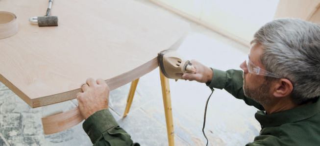 He irons on 1 1/2- or 2-inch-wide veneer edge banding, which he trims to fit. The edge banding seals the top of the door.
