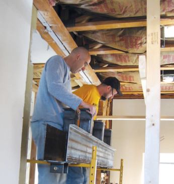 A custom-fabricated steel girder was required for the new opening in the double 2x4 fire wall separating the two condos.