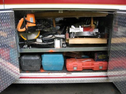 The center compartment on the left side of the module contains a shelf that has been adjusted so there is space for miter saws above and tool cases below.