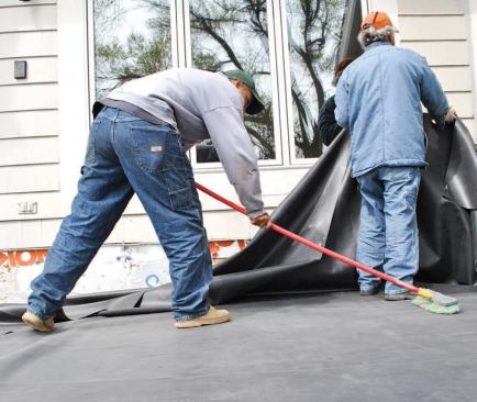 As the cement sets, a worker uses a broom to press out air bubbles and create a strong bond.