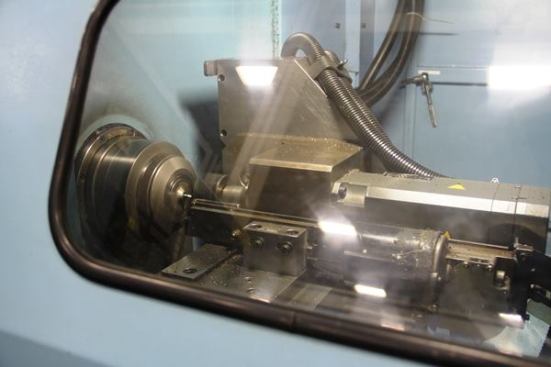 This is similar to the last machine; it’s a computer-controlled lathe being used to machine a square drive tip onto the end of a screwdriver shaft. It happens differently than you might think – there’s no stopping and starting to mill flats on each side. The chuck and cutting tool spin in a weird kind of unison and when they stop the end of the shaft has been milled square. I saw it happen several times and have no idea how the machine did it.