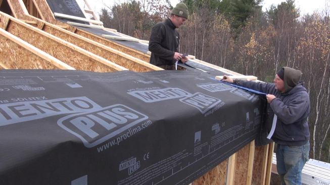 Taping the fabric seams at the other end of the shed roof.