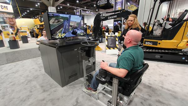 My friend Scott tries his hand at the excavator simulator at the John Deere booth. The company makes these for several machines because it's cheaper and easier to train on simulators than on the real thing.
Click here for video.