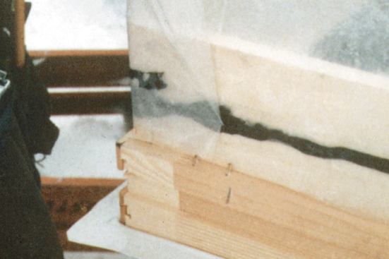 A polyethylene “bib” is added around the exterior of each window before it’s installed. Several extra pleats of poly are provided at the window corners, so that it can later be folded flat against the interior of the studs.