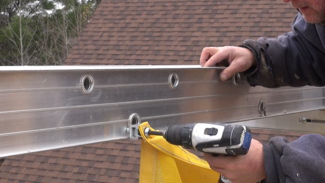 Fastening the safety net clip to the staging plank.