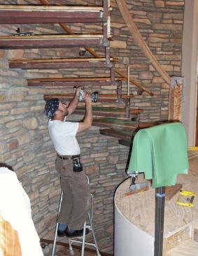 When the stonework is done and the grounds removed, the treads will slip into the recesses with no need for scribing. The tops of the treads are screwed to the frame from below.
