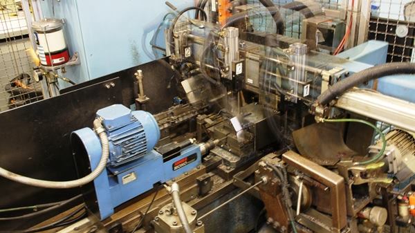 Here the straightened steel is cut to length – the exposed part of the shaft plus the part that goes into the handle. Parts of this photo are blurred because the machine is moving quite rapidly.